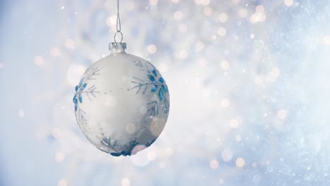 Christmas-ball-on-snow-against-blurred-fairy-lights.-New-Years-background-concept.